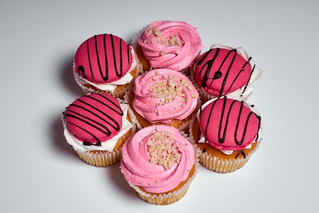 ピンクのクリームとケーキのデザートおいしいマフィン甘い御馳走白い背景の上のケーキのセット