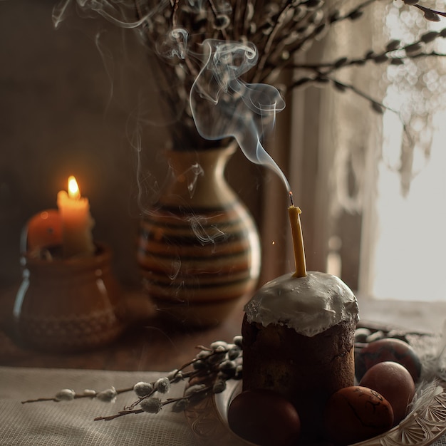 柳とキャンドルの花瓶の背景にケーキと卵
