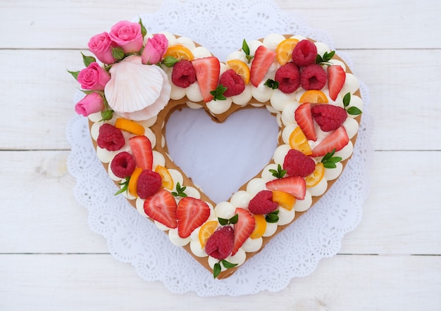 cake in the form of a heart with cheese cream and berries