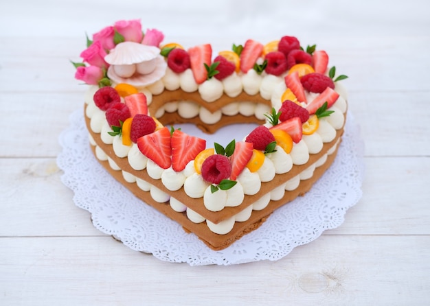 cake in the form of a heart with cheese cream and berries