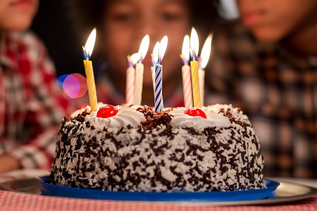 Cake in front of kids small birthday cake with candles cant wait to eat this its a very special holiday