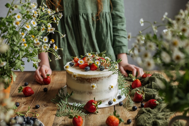 The cake is decorated with berries and flowers