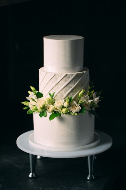 Cake is decorated with flowers on a dark .