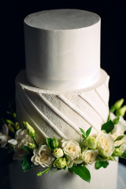 Cake is decorated with flowers on dark