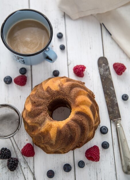 Torta. torta di marmo tazza di caffè in polvere zucchero da cucina utensile vintage e frutti di bosco freschi.