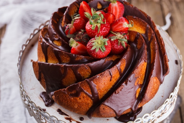 Cake met aardbeien en chocolade glazuur op de basis.