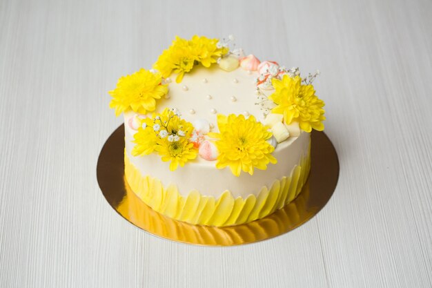 Cake met gele vlekken, gele chrysanten en meringue