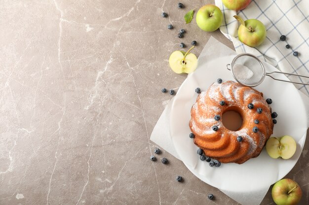 Cake met poedersuiker, bosbes en appels op grijze achtergrond