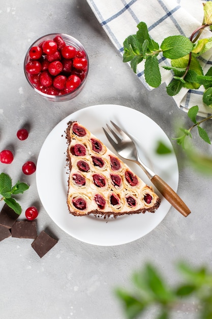 Cake "Monastic hut" with a cherry on a white plate on light background