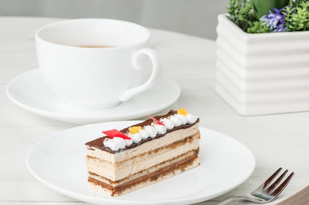 皿の上のケーキと花のテーブルの上のコーヒーのカップ