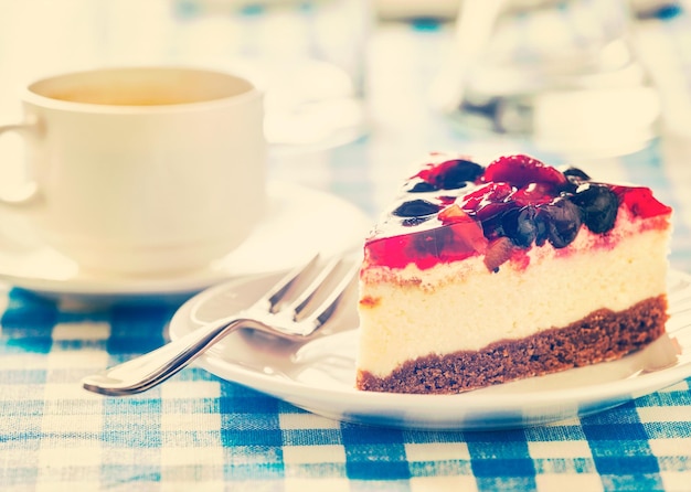 포크와 커피 컵이 있는 접시에 케이크