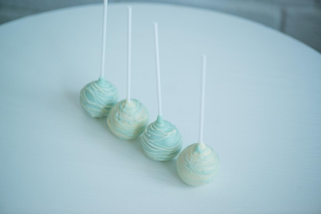 cake pops on a stick on a white background, lying on the table