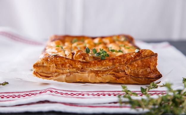 Cake of puff pastry with savory stuffing and thyme