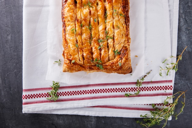 Cake of puff pastry with savory stuffing and thyme