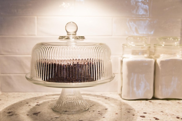 Photo cake in stand on table against wall