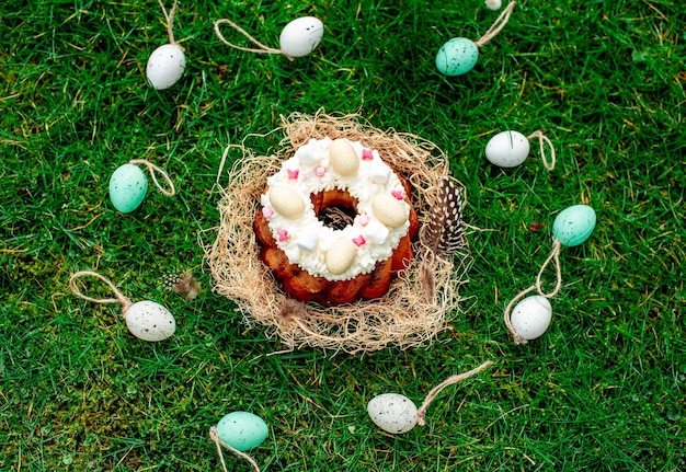 A cake surrounded by easter eggs on the grass