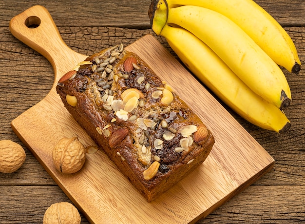 cake with banana and nuts on wooden board