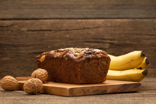 cake with banana and nuts on wooden board