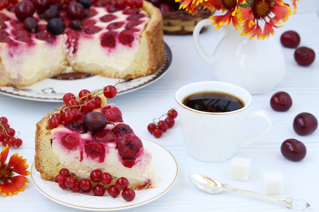 Cake with berries on a plate and coffee in a cup