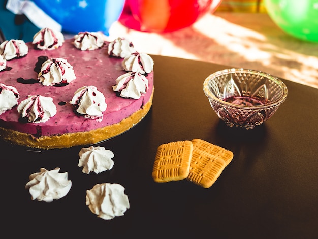 Foto torta con mirtilli e biscotti e marshmallow in cima.