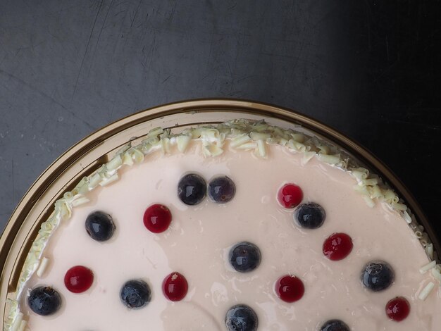 Foto una torta con mirtilli e glassa bianca su un tavolo.