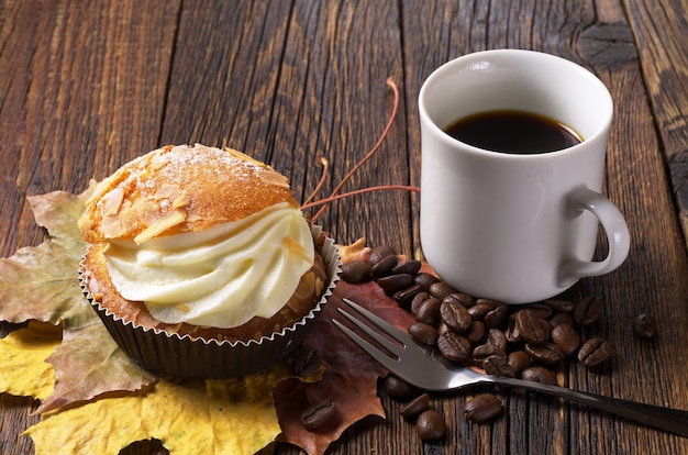 Photo cake with butter cream and cup of coffee on wooden table