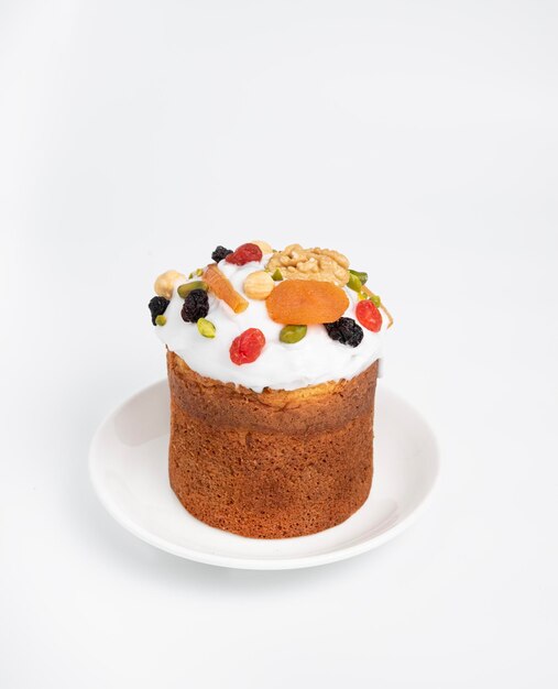 白い背景の白い皿の上に甘いフルーツとアイスが付いたケーキ イースターの休日のコンセプト