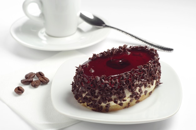 Torta con gelatina di cioccolato e ciliegie su fondo bianco