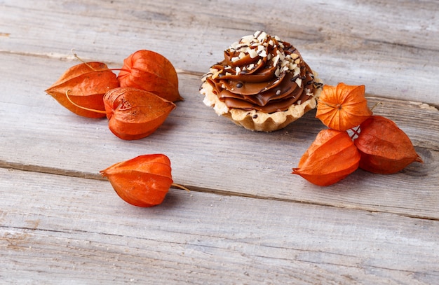  cake with cream and physalis  on a  wooden background