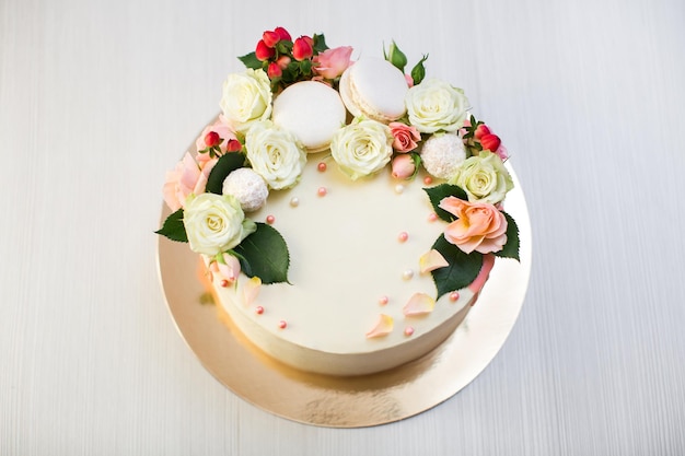 Cake with fresh flowers and macaroons