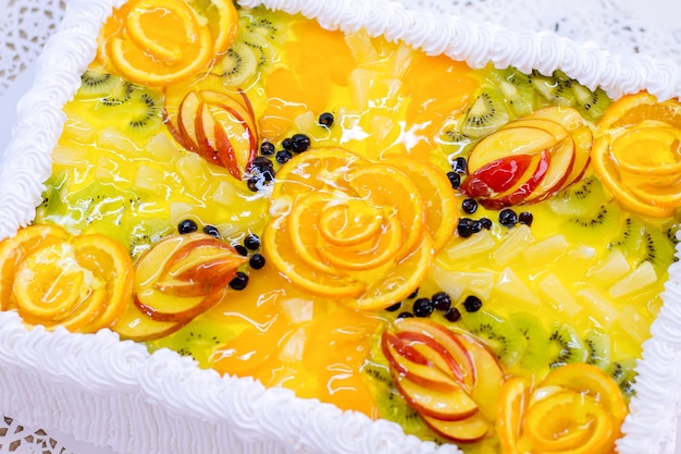 Cake with fruits and jelly. Sliced orange and kiwi. Top view of exotic dessert. Custom made confectionery product.