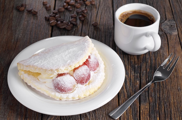 Foto torta con uva e caffè su un tavolo di legno