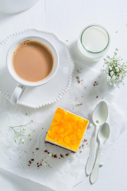 Cake with jelly and peaches served with coffee