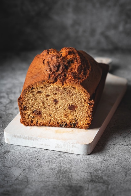 Photo cake with raisins on a wooden board, homemade baked goods with dried fruits, copy space, gray background