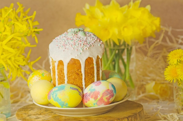 Cake with sprinkles and easter eggs Easter cake by festive attributes Easter composition with cake coloured eggs and flowers