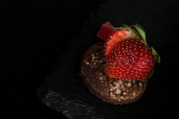 Cake with strawberries on dark background decorative stone