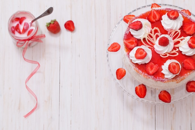 Cake with strawberries on white wooden table