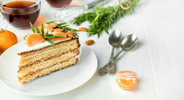 Cake with tangerines and rosemary on a light table Copy space