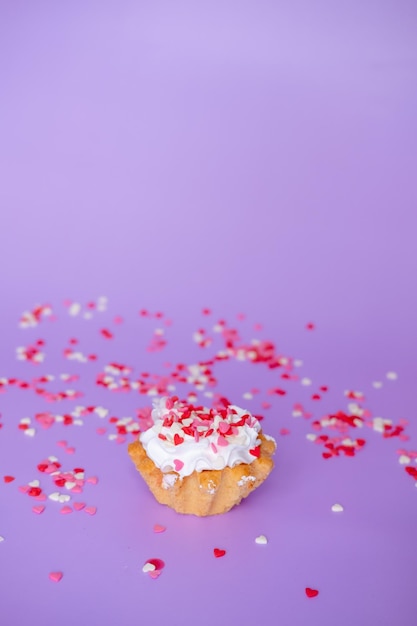 Photo cake with whipped cream studded with small hearts on a purple background valentines day and birthday concept