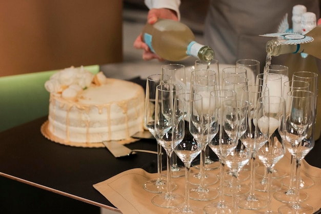 A cake with white frosting and a champagne bottle