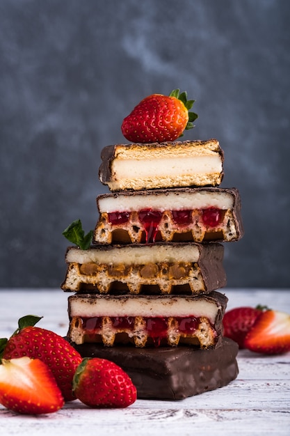 Cakes and wafers covered with chocolate and strawberries