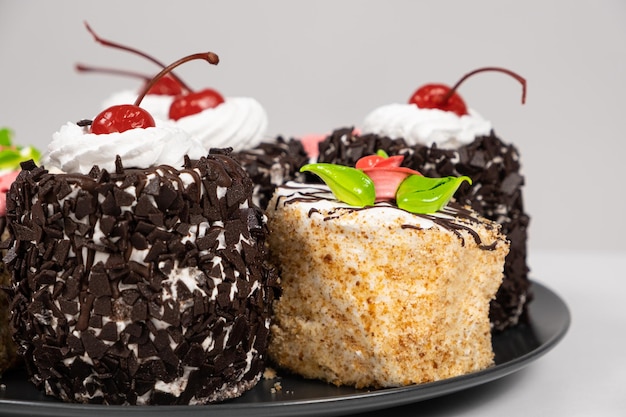 Cakes with chocolate cherries and cream on a white background