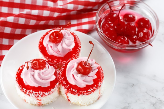 Cakes with cream and cherry Close up of a cup cake with cherry