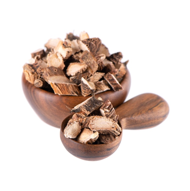 Calamus root in wooden bowl and spoon isolated on white background Sweet flag sway or muskrat root Dry root of Acorus calamus