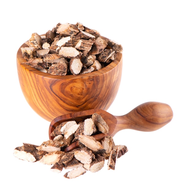 Calamus root in wooden bowl and spoon isolated on white background Sweet flag sway or muskrat root Dry root of Acorus calamus