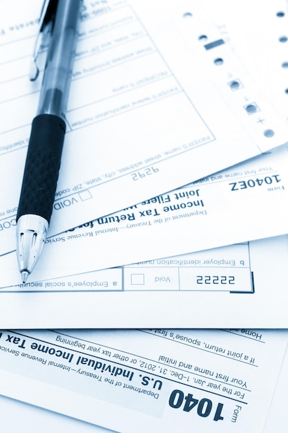 Calculating numbers for income tax return with pen and calculato