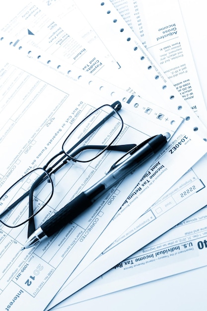 Calculating numbers for income tax return with pen and calculato