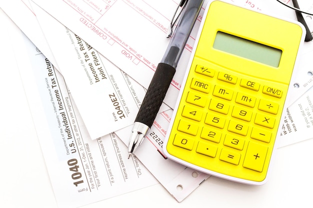 Calculating numbers for income tax return with pen and calculato