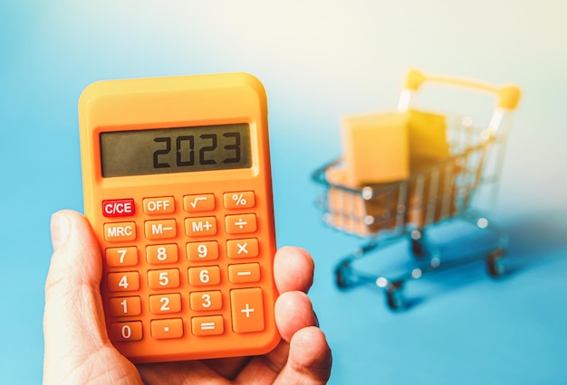 Calculator 2023 on the background of a supermarket trolley Shopping concept Online sales Ecommerce and sale of goods through online trading platforms Business concept