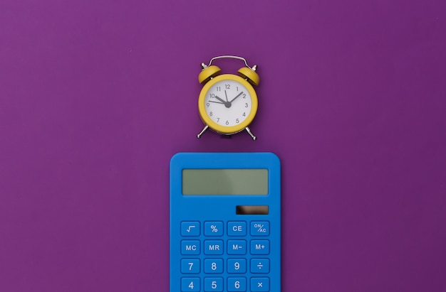 Calculator and alarm clock on purple background.